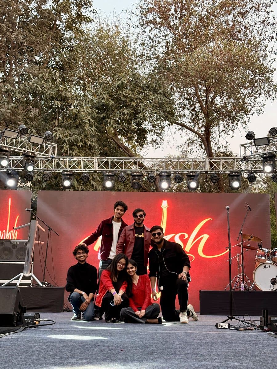 Moksh on stage at BIMTECH, in front of the band's name in lights.